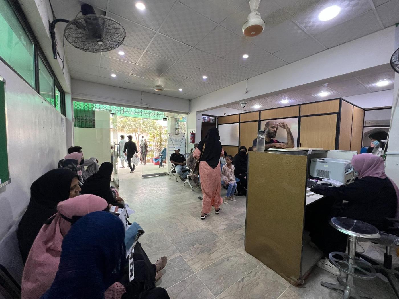 Patients waiting at a hospital front desk in Karachi