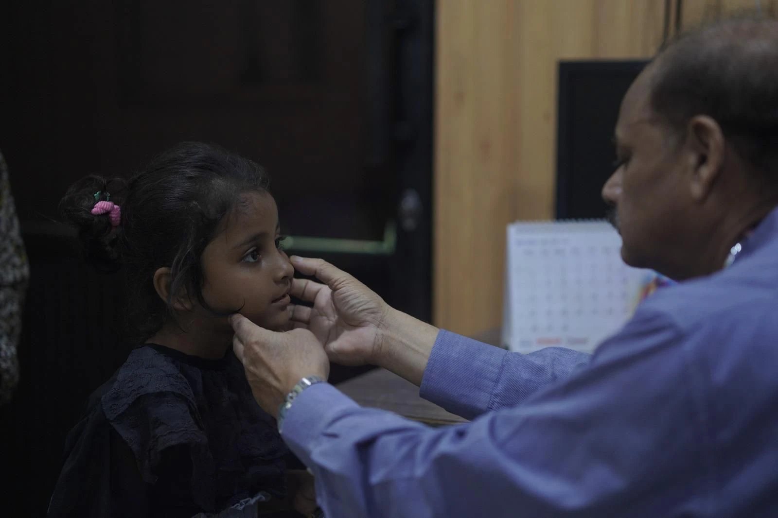 A doctor examines a young girl at the Thaakat clinic in Karachi